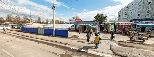 У остановки рядом с уличной торговой точкой начали демонтаж навесов и прилавков; пенсионеры-торговцы овощами вынуждены прятаться от солнца зонтиками и искать новые места.